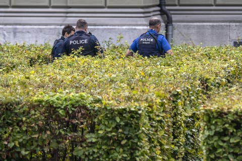 Polizisten durchsuchen die Büsche vor dem Bundeshaus West.