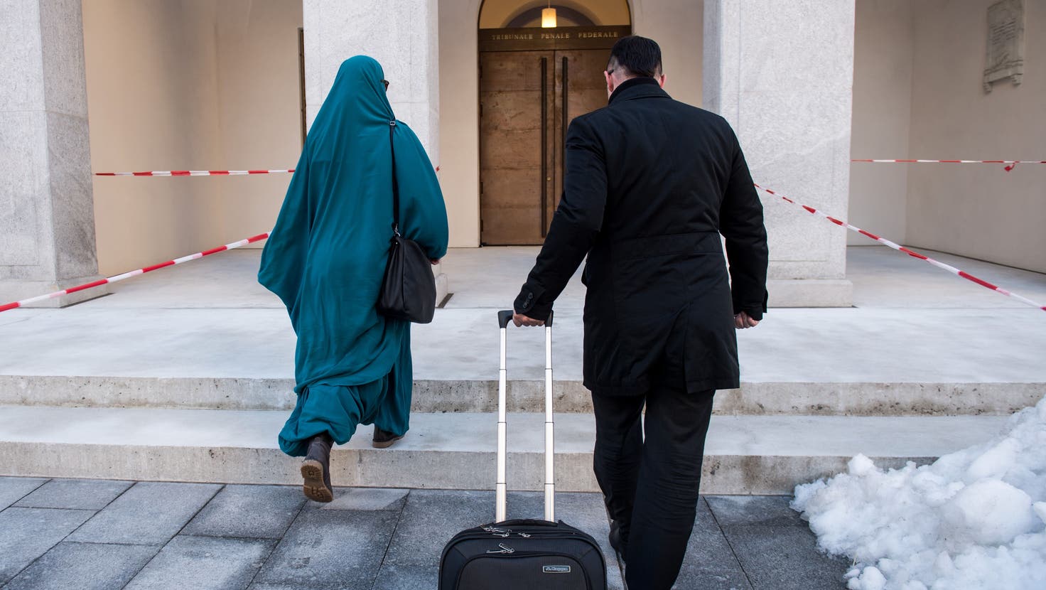 Eine mutmassliche Dschihad-Reisende, links, trifft vor dem Bundesstrafgericht in Bellinzona ein, am Freitag, 15. Dezember 2017. Damals wurde der Sohn verurteilt, jetzt stet die Mutter vor Gericht. (Gabriele Putzu/Keystone/Ti-PRESS)